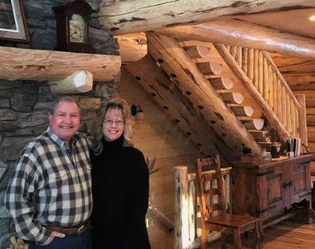 Picture of a man and woman inside a log home.