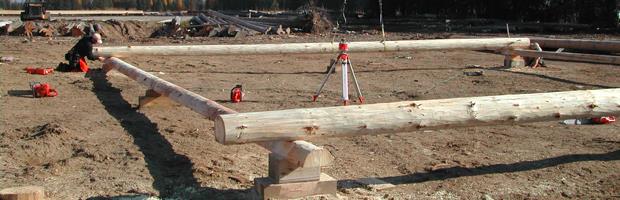 Four large wooden beams in a square as the start to a log home build.