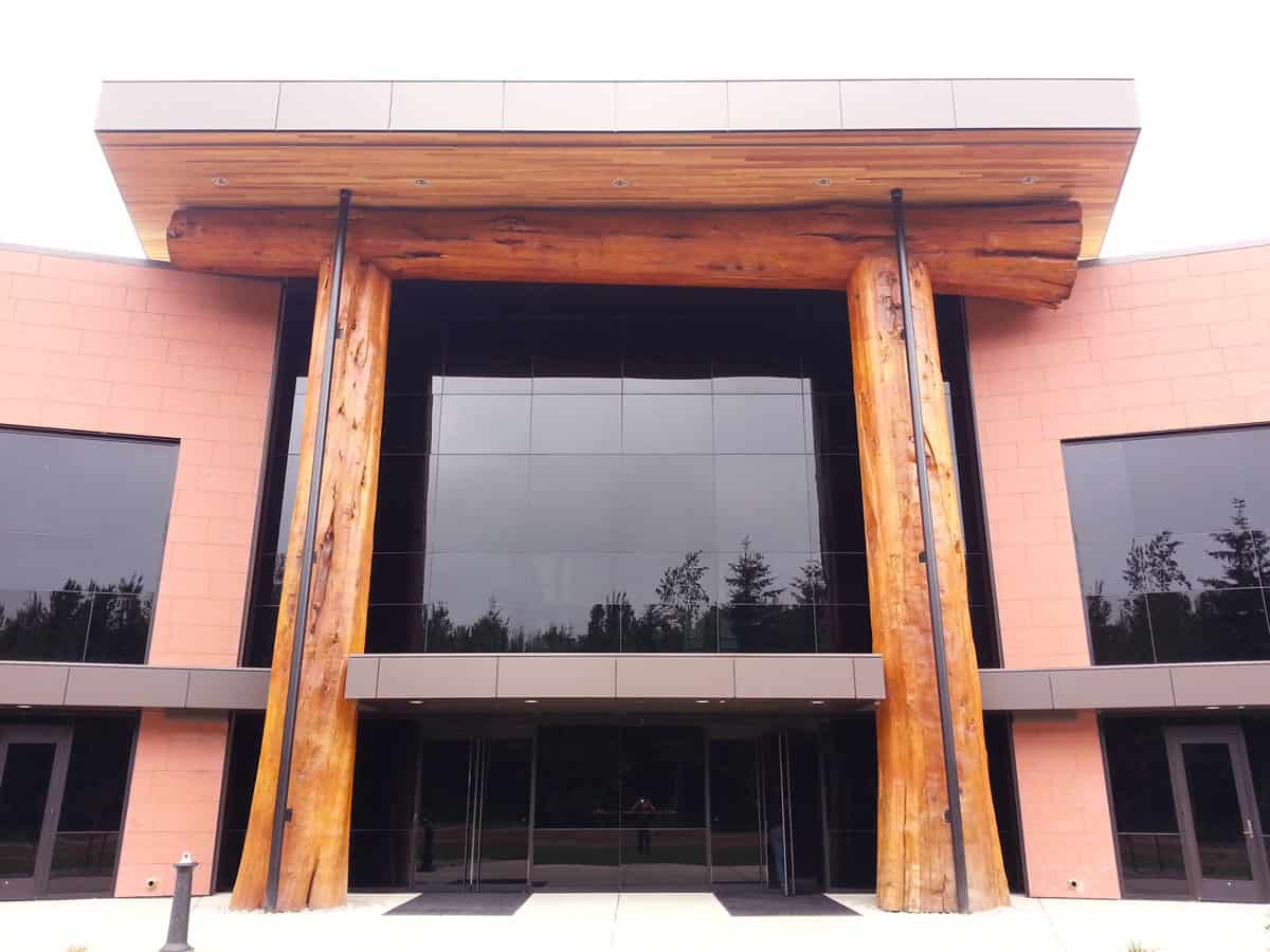Large wooden support beams on the exterior of a tribal building.