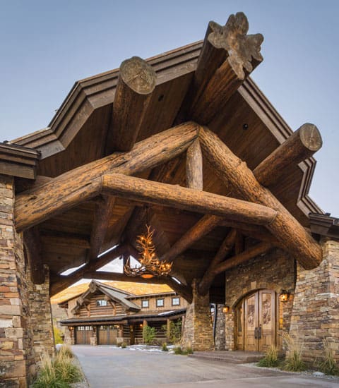 Exterior full timber entry way to a very large log home.