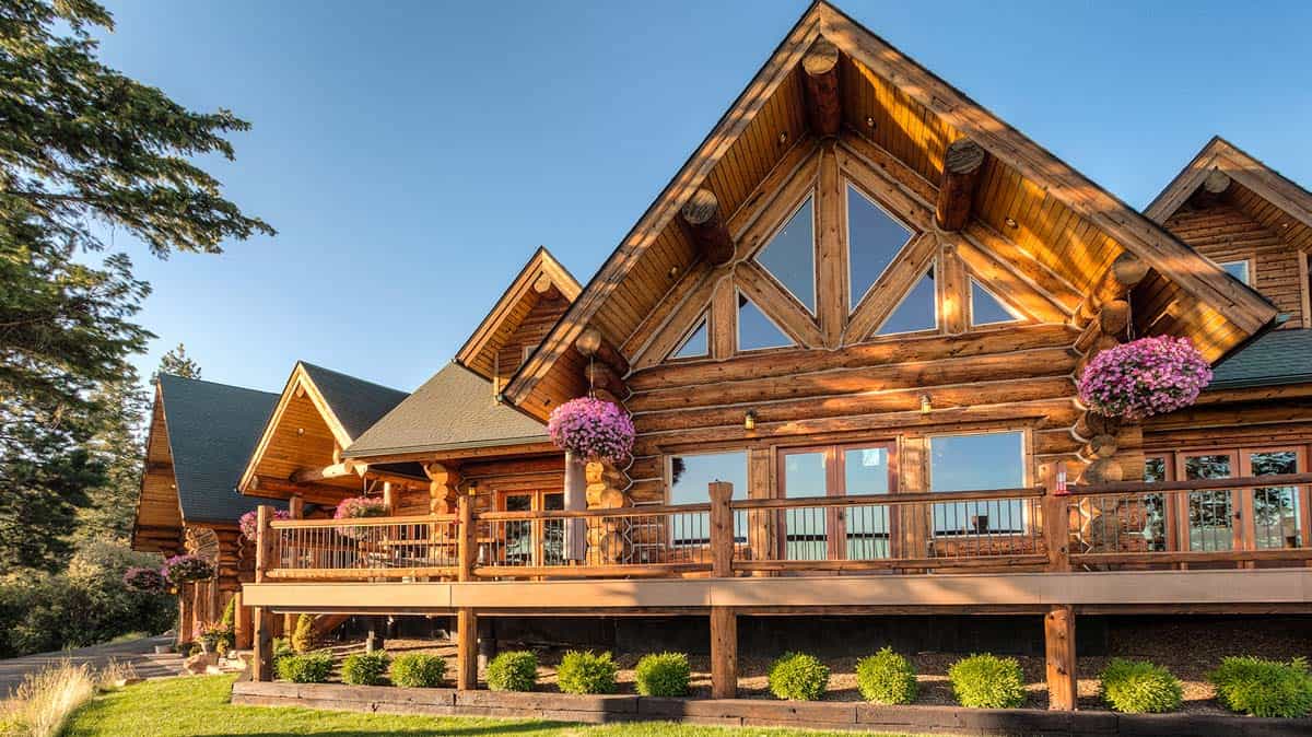 Beautiful chink style log home with large deck and nice landscaping.