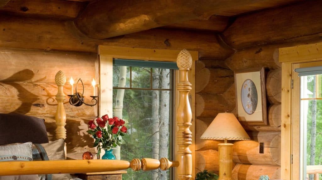 Bedroom in a log home with multiple windows.