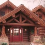 Exterior entry way to a log home built with full timber trusses.