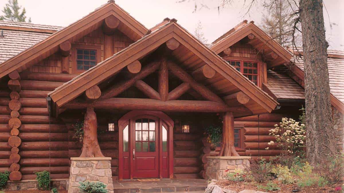 Exterior entry way to a log home built with full timber trusses.
