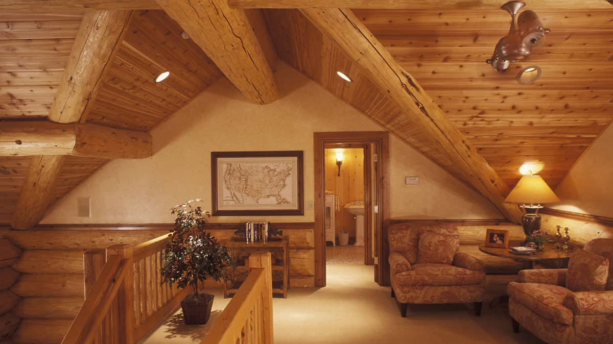 Second floor landing area, with plush chairs, in a log home.