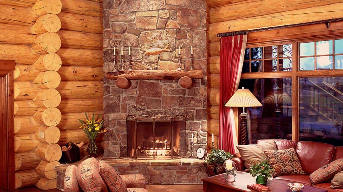 Large rock finished fireplace in a living room of a log home.