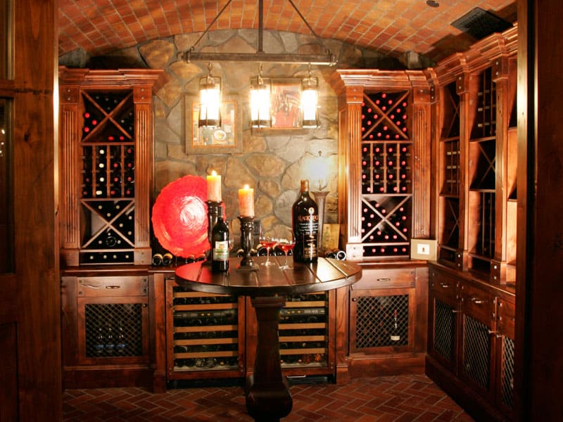 Image of a custom built wood cabinet wine room with shelves of wine bottles.