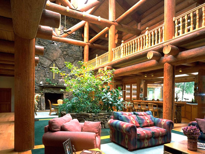 Interior of Hidden Lakes Golf resort. Large seating area with fireplace, couches and big log construction.