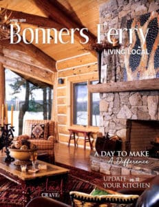 Cover of Bonners Ferry Living Local magazine - log home interior looking out over a lake.