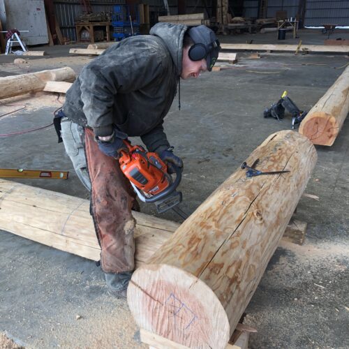 Image of a log crafter using a chainsaw on a log
