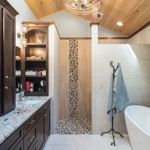 Modern lighting and dark cabinetry adds the perfect touch of modern to this log home bathroom.