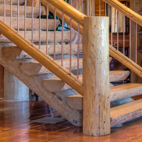 Custom handcrafted staircases are a great addition to any cabin. Did you notice the copper railing?
