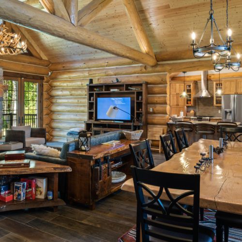 This custom log home is designed with a great room living room combo.