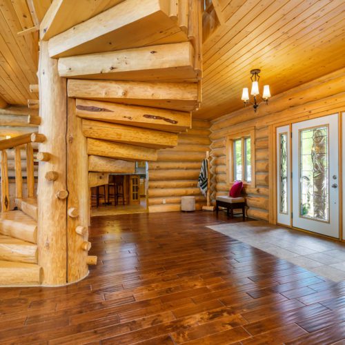 Walking into this log home you are greeted by a gorgeous custom staircase.
