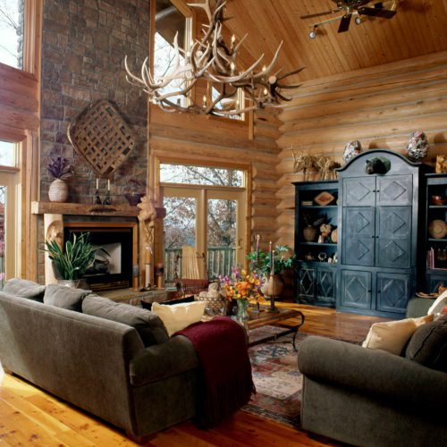 This North Idaho home is decorated with an antler chandelier, a stone fireplace, and gorgeous windows.