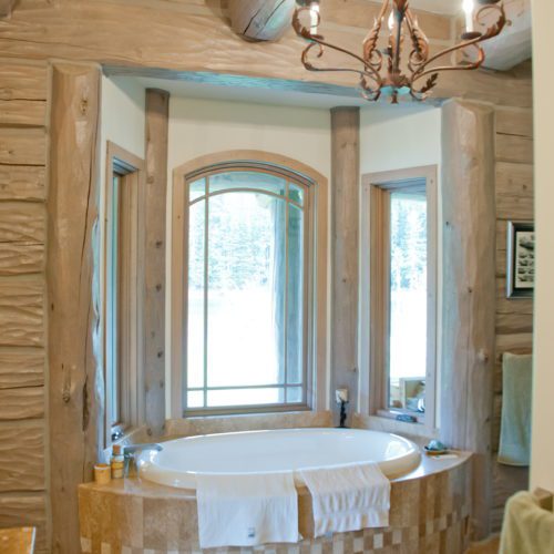 A tub fit for a queen accents this custom log home bathroom.