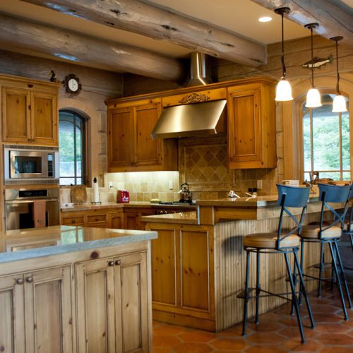 More of a modern flare, this log home kitchen is accented with a breakfast bar.