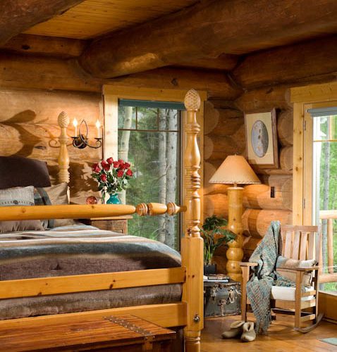 With its Cute Country Cottage vibe - this log home bedroom is decorated with a 4 post bed and plenty of natural light.