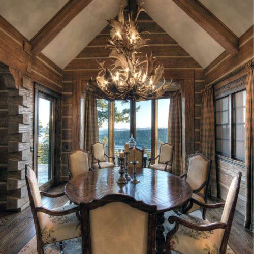 This romantic dovetail log home dining room is furnished with a beautiful oval table.