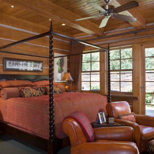A stately 4 post bed and walk out doors, makes this dovetail log home bedroom a cozy site.