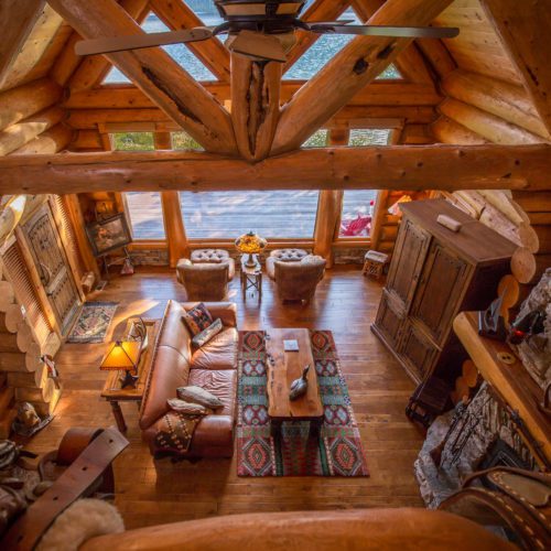 The rustic log truss makes this log home living room unique.