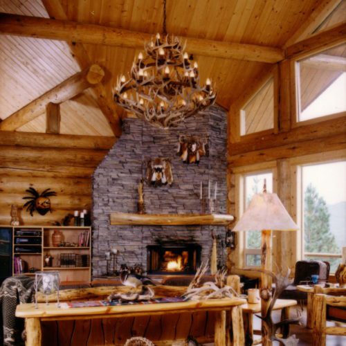 Rustic western themed living room with stone fireplace.